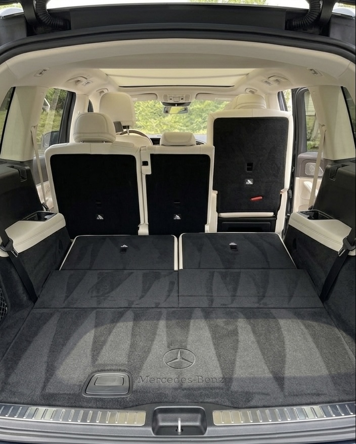 Mercedes-Benz SUV trunk interior after detailing — clean carpet, folded rear seats