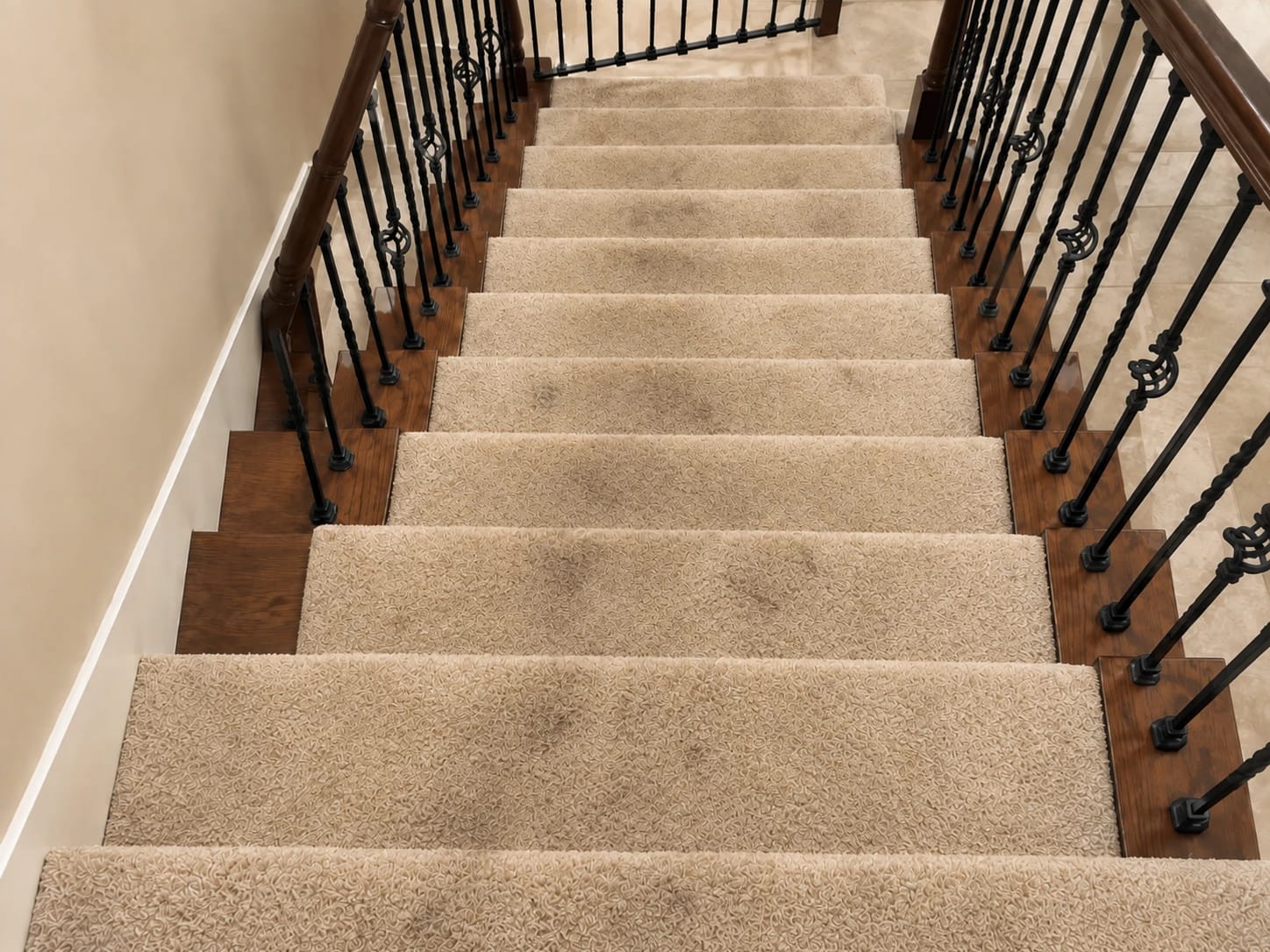 Before — carpeted staircase with dark traffic stains on every step